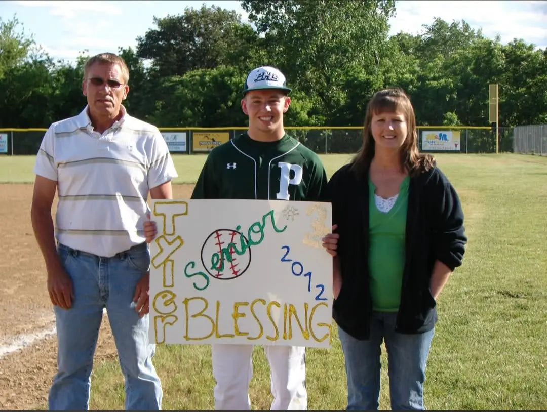 David Blessing in a Perryville baseball uniform with his parents on the field